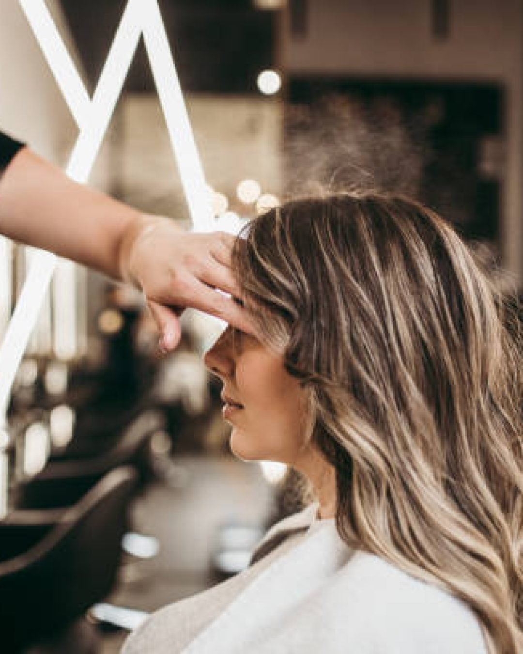 Beautiful brunette woman with long hair at the beauty salon getting a hair blowing. Hair salon styling concept.